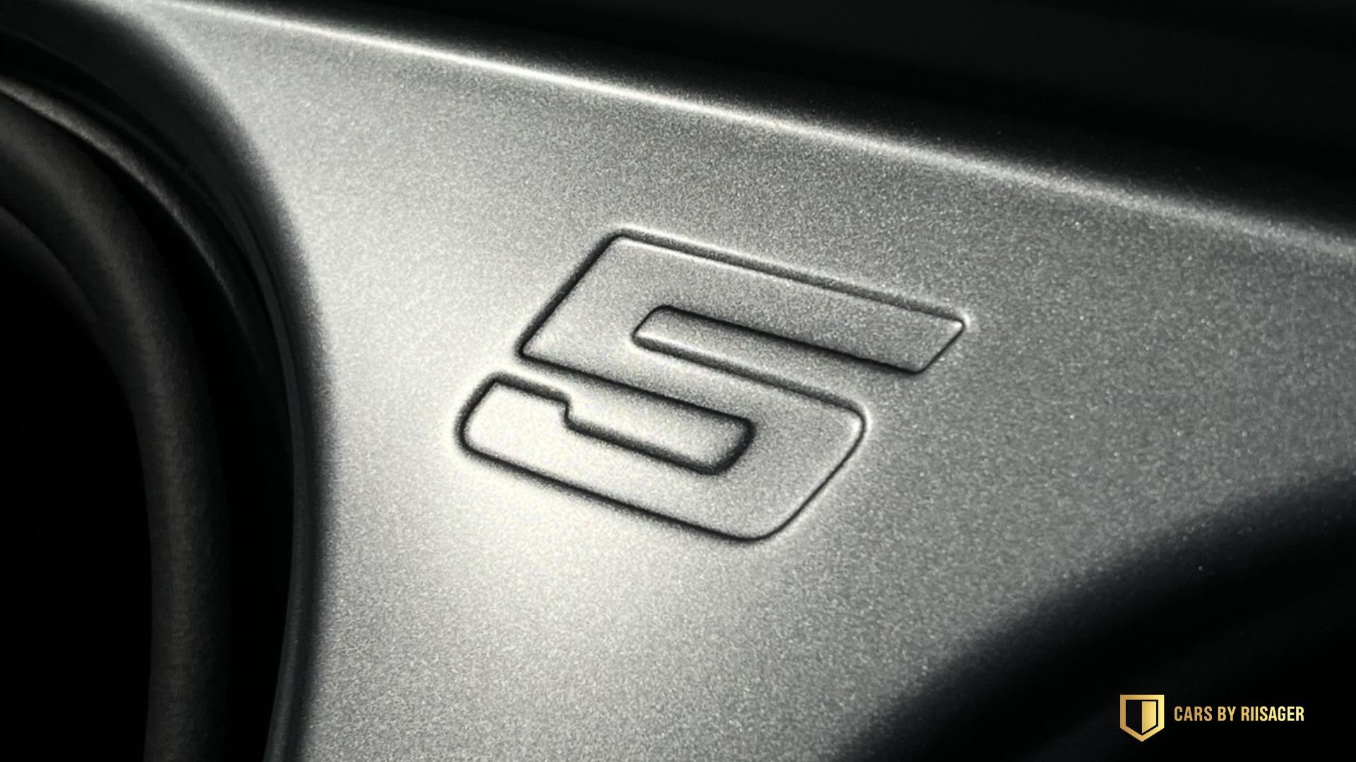 Indpræget 5-tal i en mørk detalje på BMW i5 Touring.