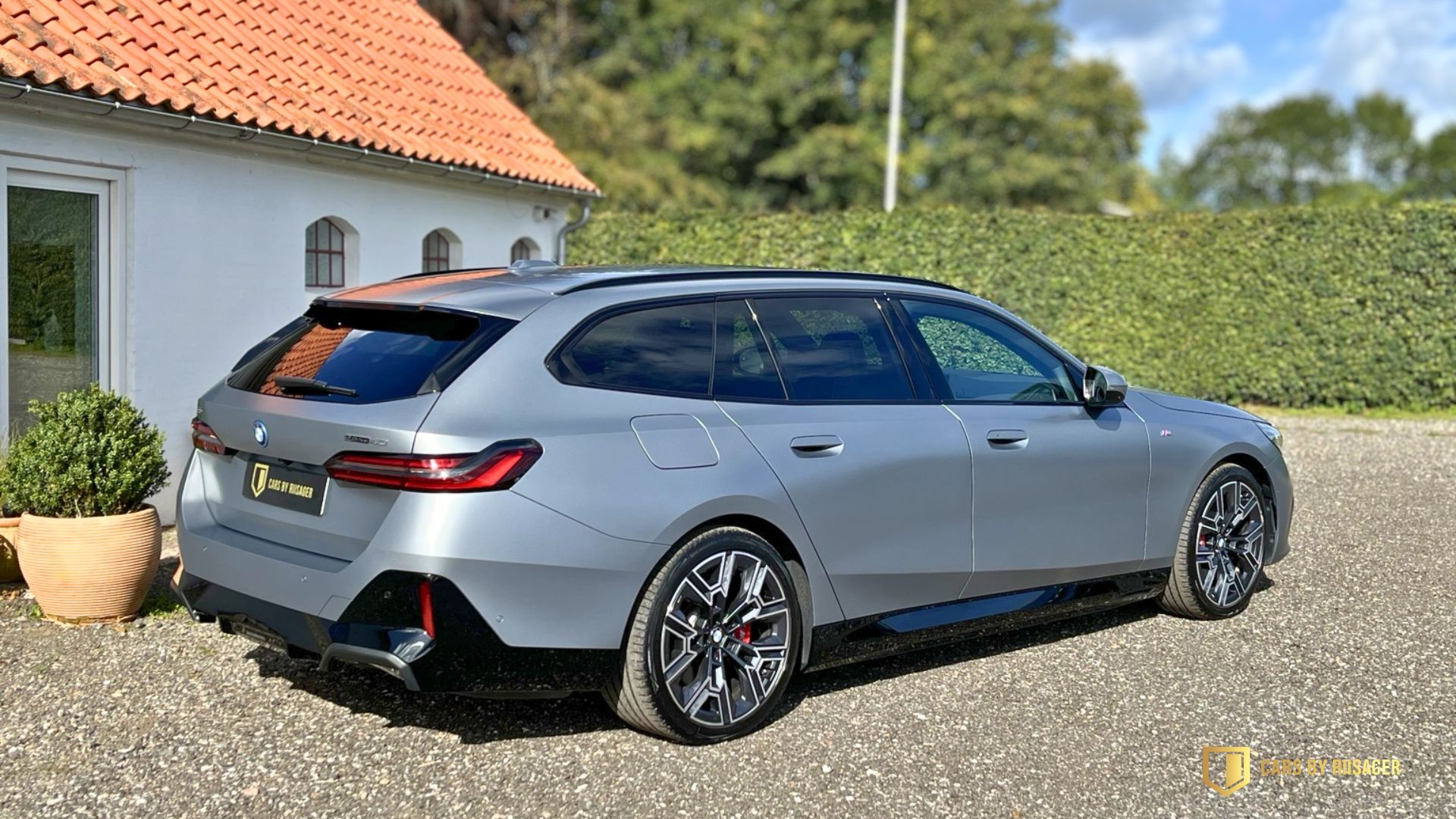 Grå BMW i5 Touring med mat lak fotograferet skråt forfra foran Cars by Riisager.