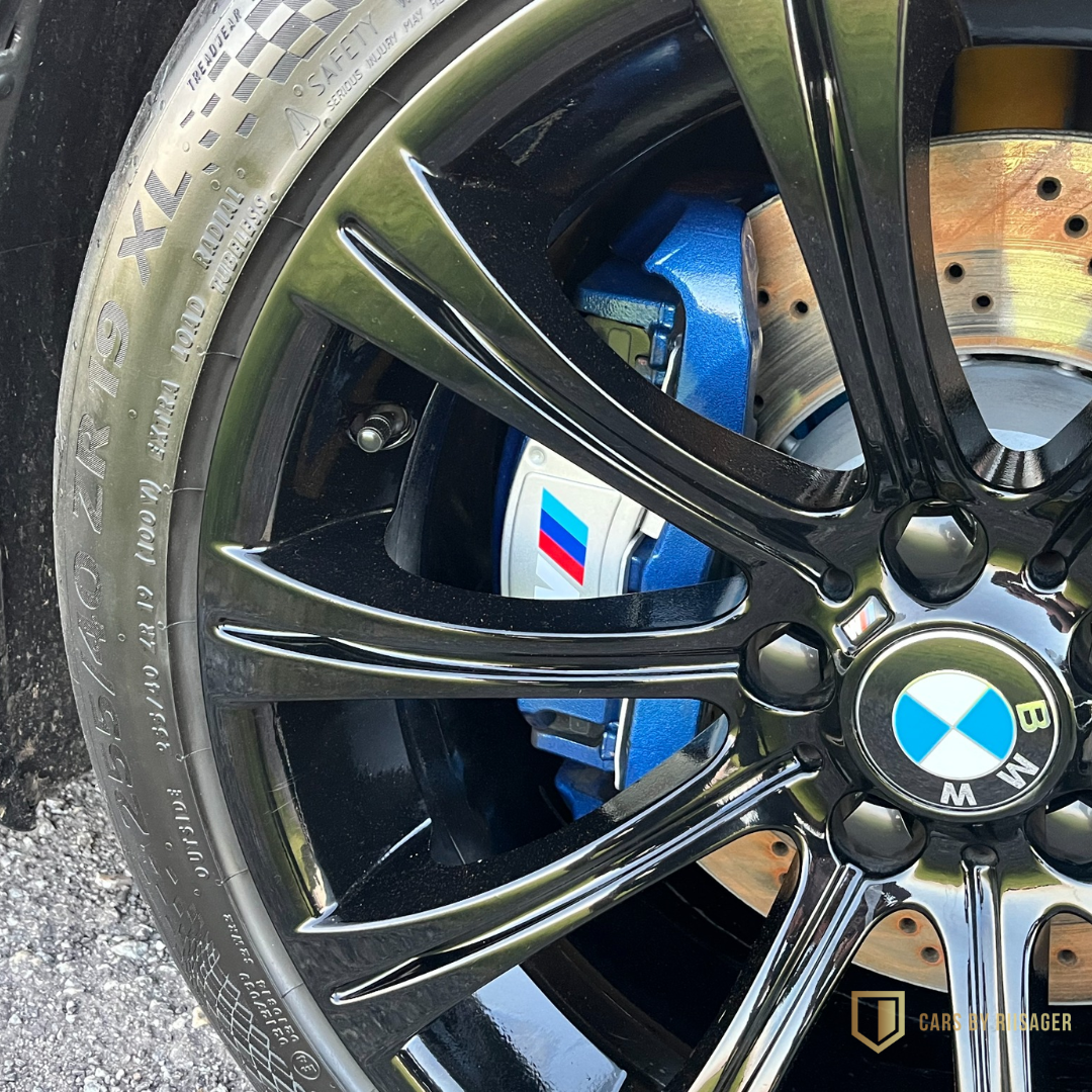 bmw-m5-e60-bremser-m-performance Nærbillede af BMW M5 E60 fælg og blå M Performance-bremsekaliber.