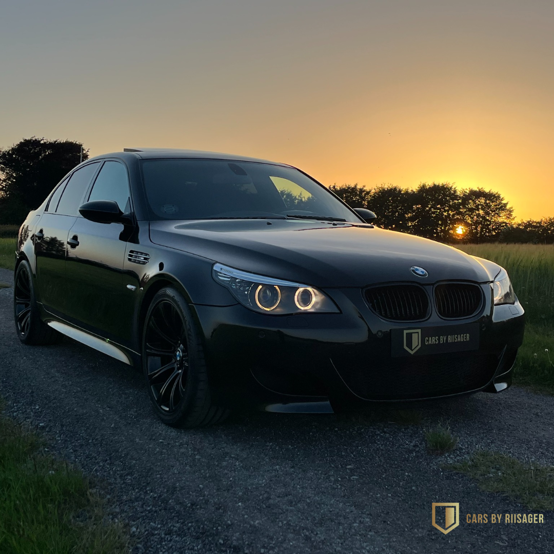 bmw-m5-e60-sort-solnedgang-sideprofil BMW M5 E60 i sort set fra siden ved solnedgang på en landevej i Nordjylland.